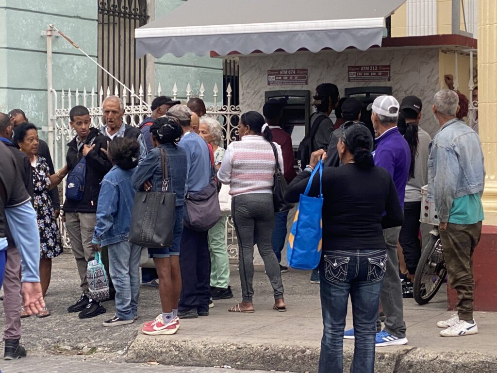 Personas haciendo cola en cajeros automáticos