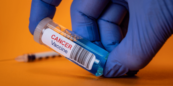 Vial de vacuna contra el cáncer en manos enguantadas