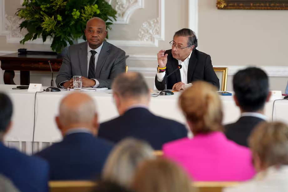 Dos hombres en reunión ejecutiva con público atento