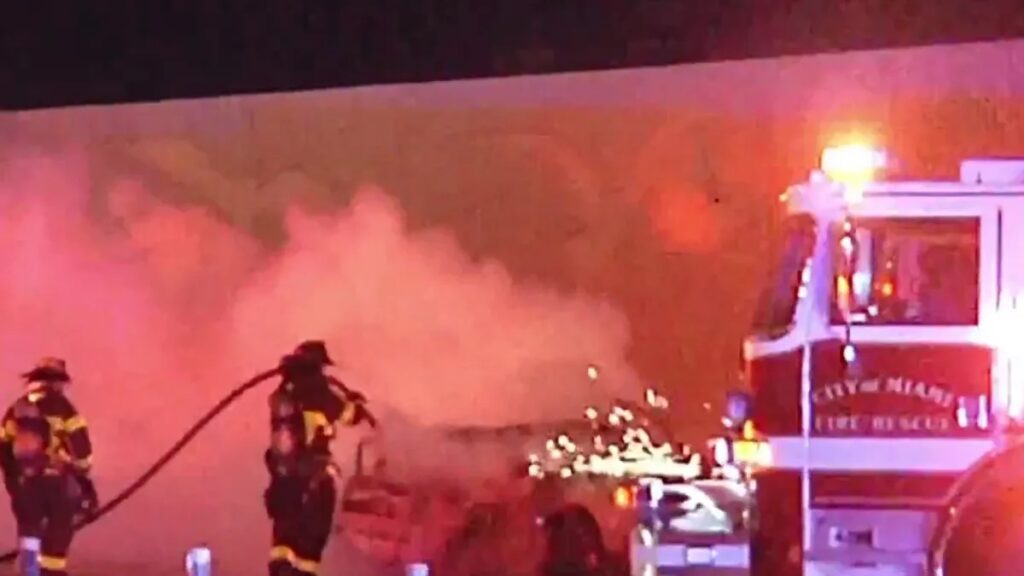 Bomberos apagando incendio nocturno vehicular