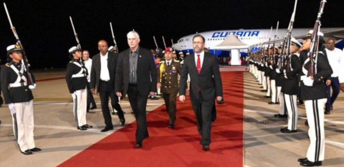 Funcionario caminando por alfombra roja con escolta militar