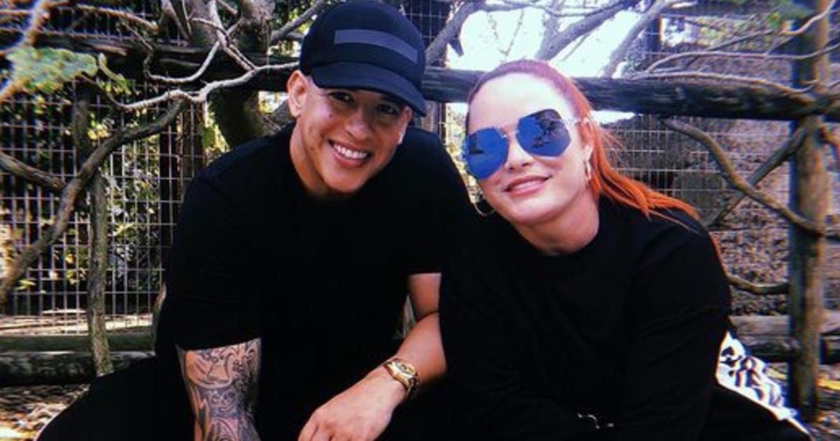 Pareja sonriente en parque con gafas de sol