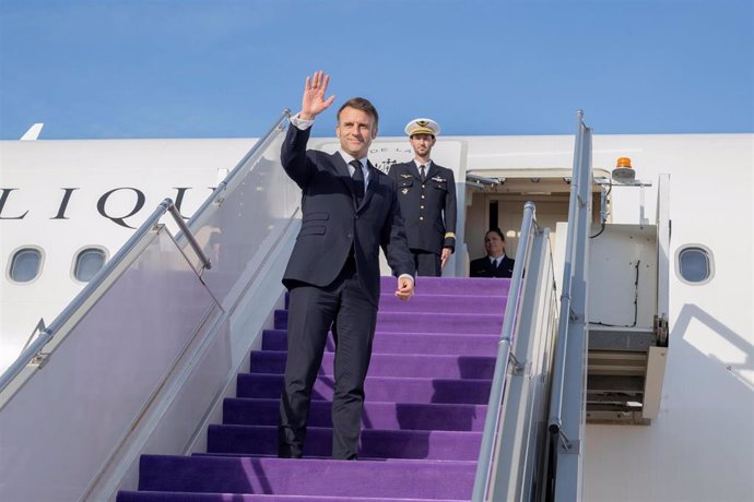 Hombre bajando escaleras de avión y saludando