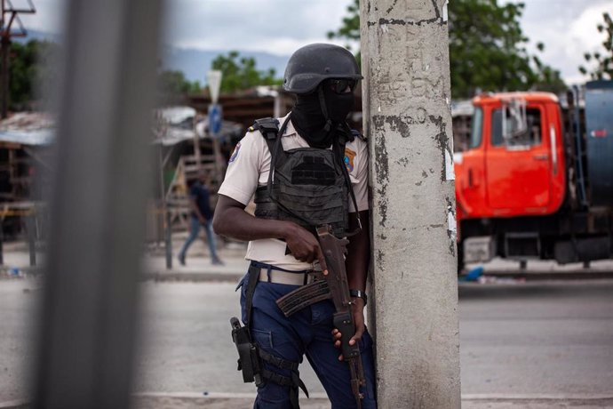 Policía armado vigilando en calle urbana