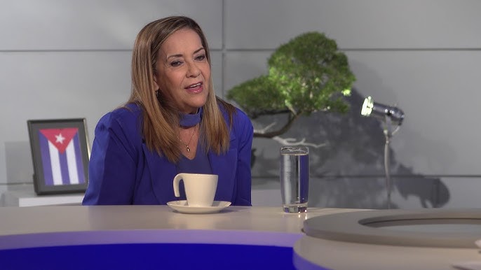 Mujer hablando en un set de televisión con taza