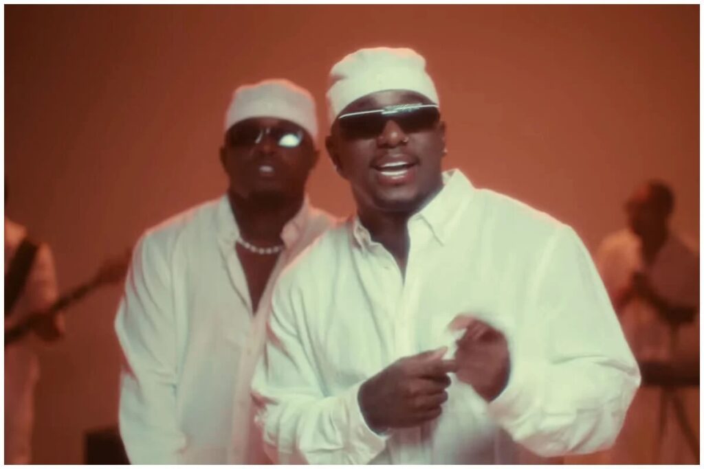 Dos hombres con ropa blanca cantando y bailando