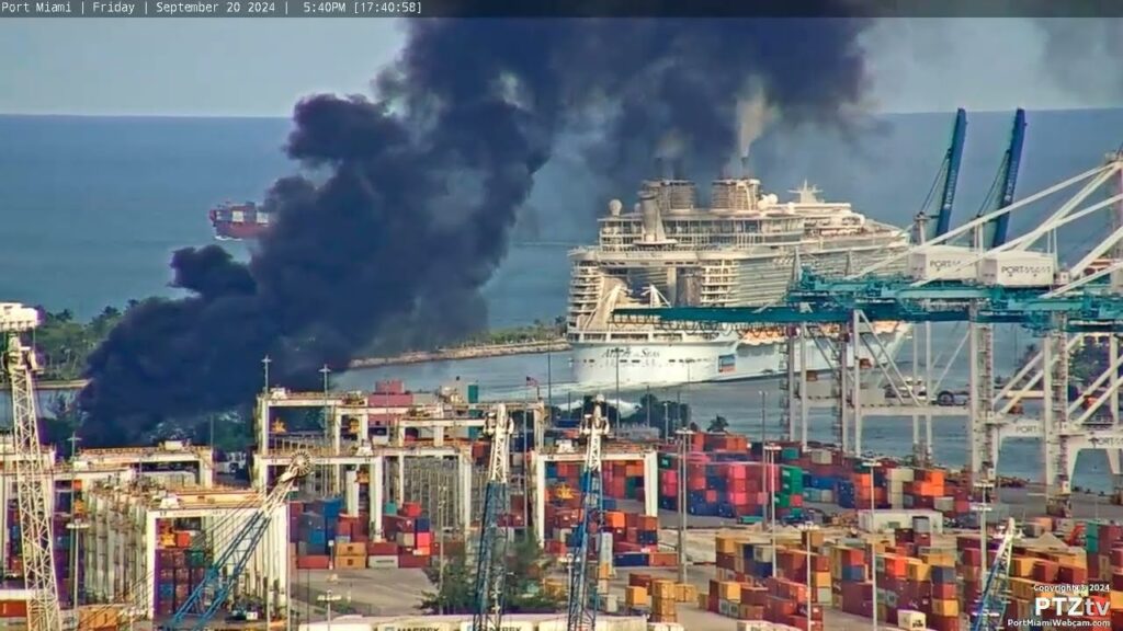 Incendio grande en puerto con barcos y contenedores