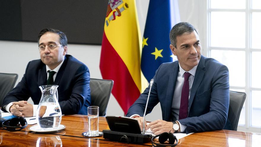 Dos hombres en reunión oficial con banderas de España
