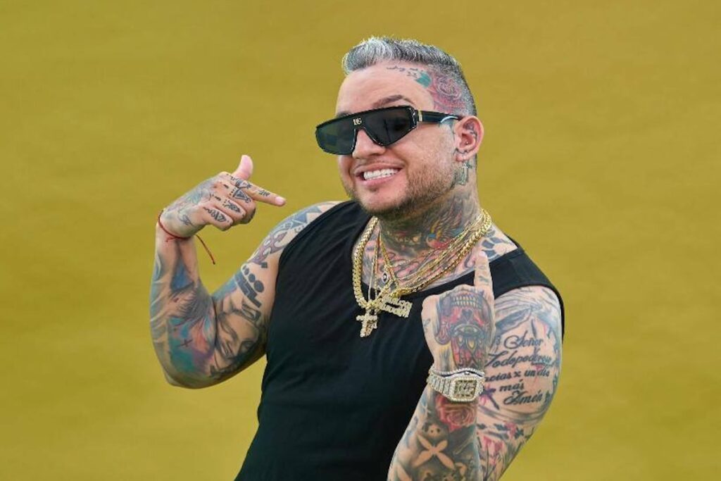 Hombre sonriente con tatuajes y gafas de sol