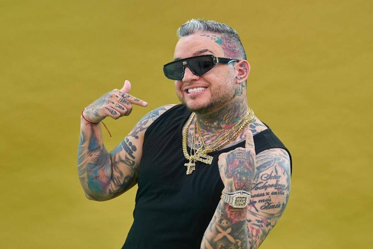 Hombre sonriente con tatuajes y gafas de sol