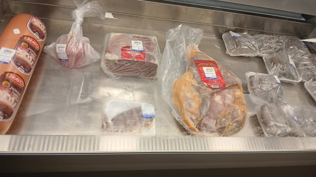 Diferentes carnes empaquetadas en refrigerador de supermercado