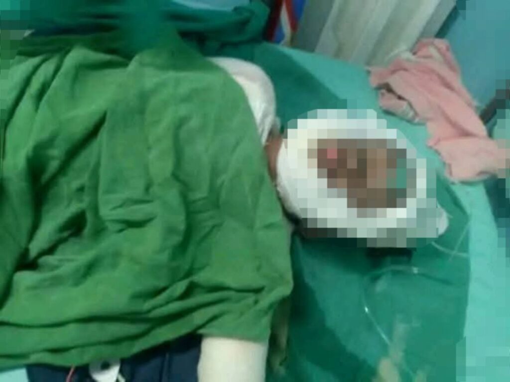 Persona recostada con manta verde, ambiente casero.