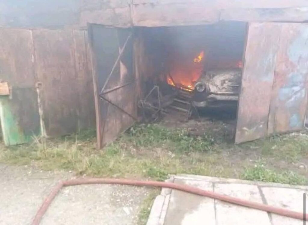Coche ardiendo dentro de un garaje abierto