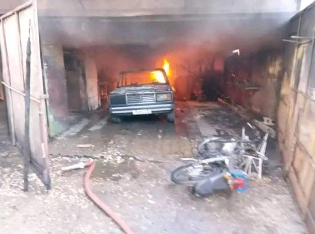 Furgoneta ardiendo en garaje desordenado