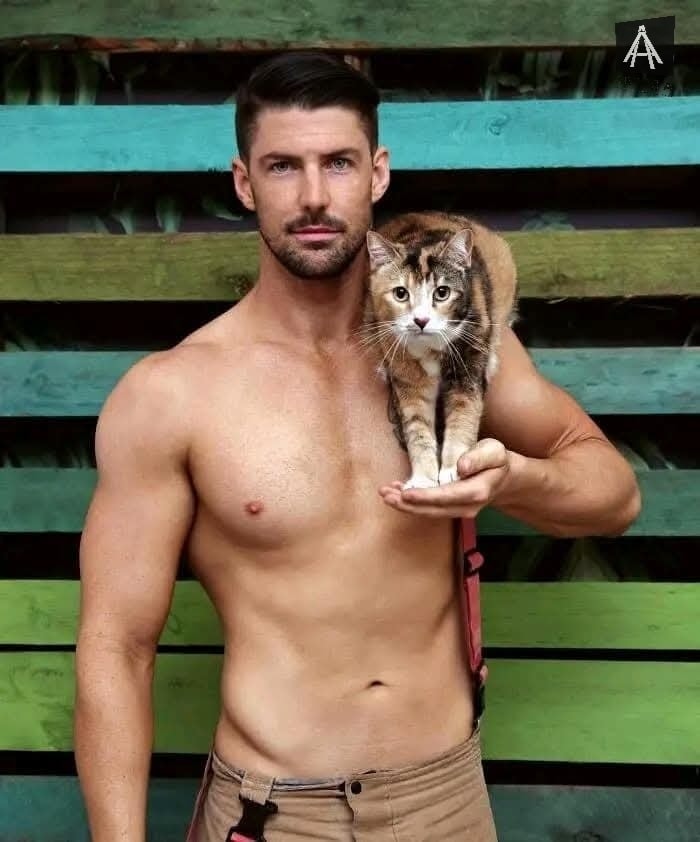 Hombre sin camisa sostiene un gato tricolor
