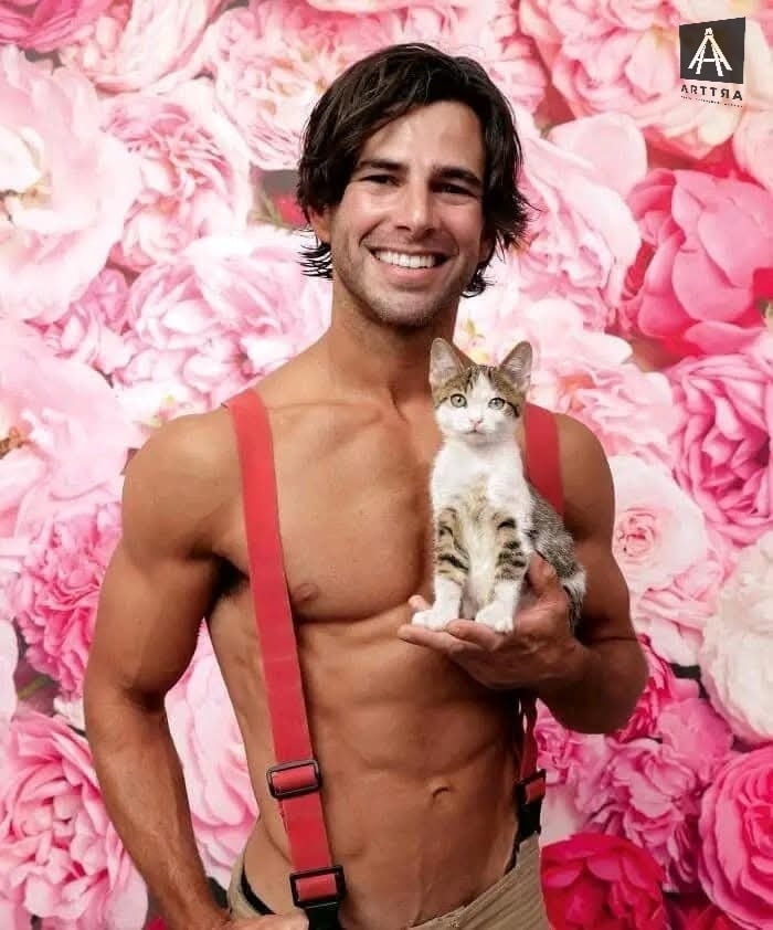 Hombre sonriente con gato frente a fondo floral