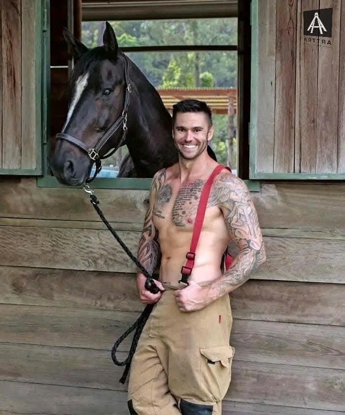 Hombre sonriente con caballo en establo