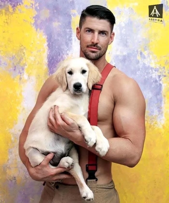 Hombre con camiseta roja sosteniendo cachorro dorado
