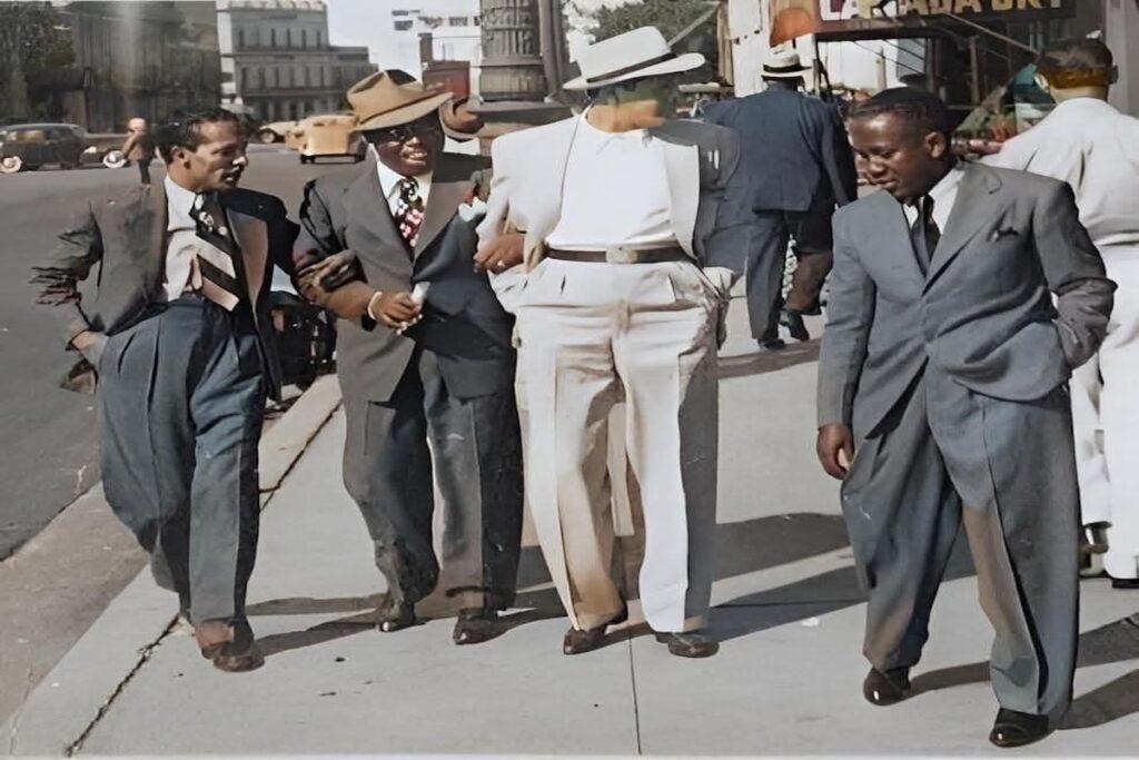 Cuatro hombres caminando juntos en ciudad años cincuenta