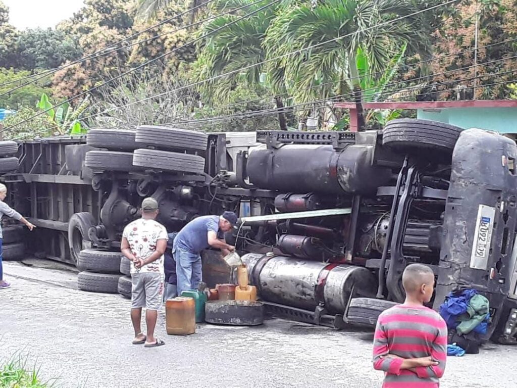Camión volcado en carretera con personas observando