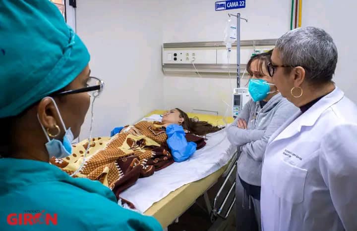 Niña en hospital con médicos observando