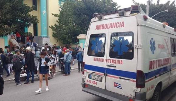 Ambulancia y multitud en calle urbana