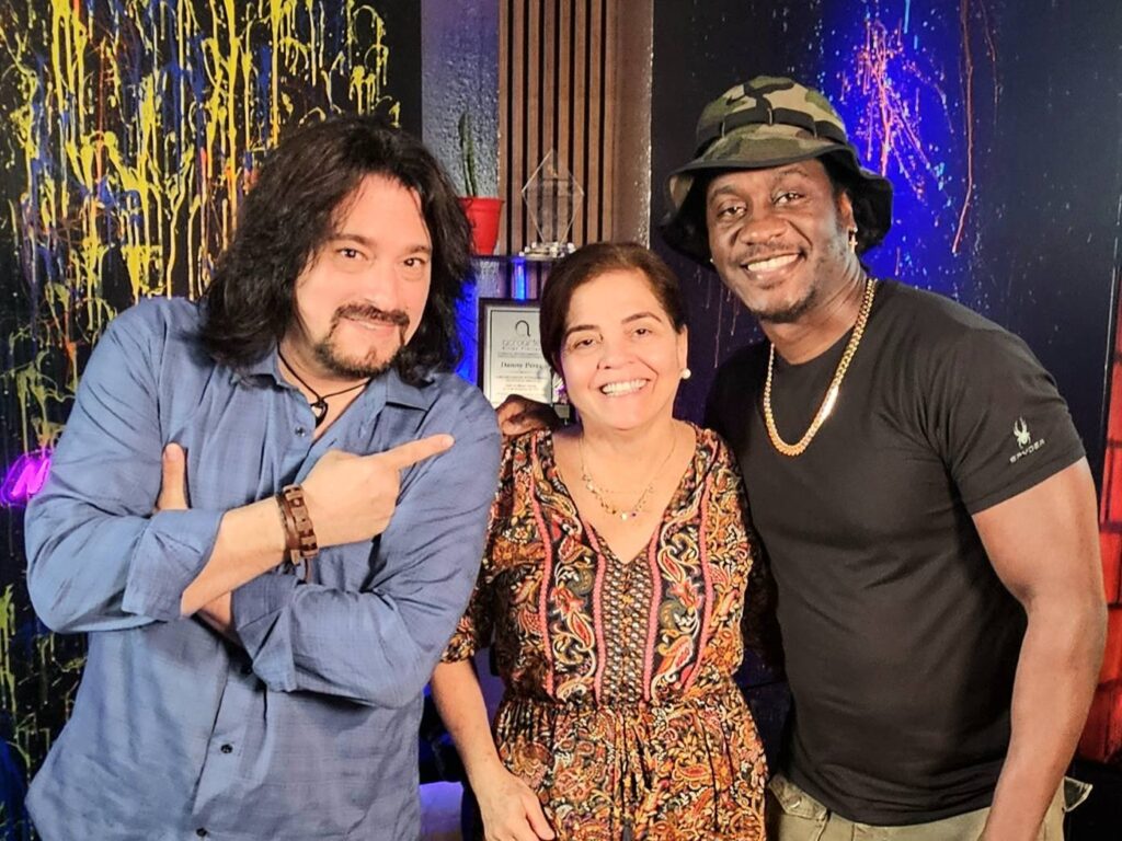 Tres personas sonriendo en un estudio colorido