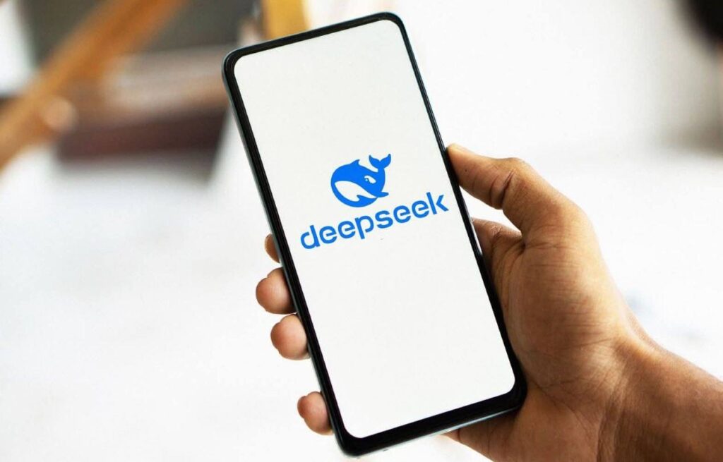 Mano sostiene móvil con logo Deepseek en pantalla