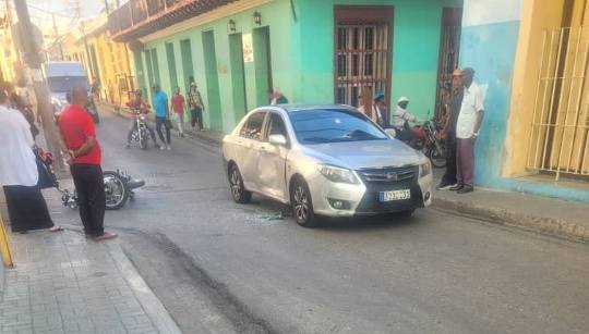 Coche plateado averiado en calle concurrida