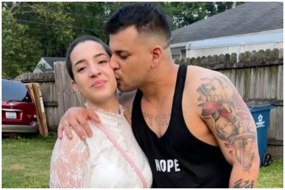 Hombre besando mejilla de mujer en jardín