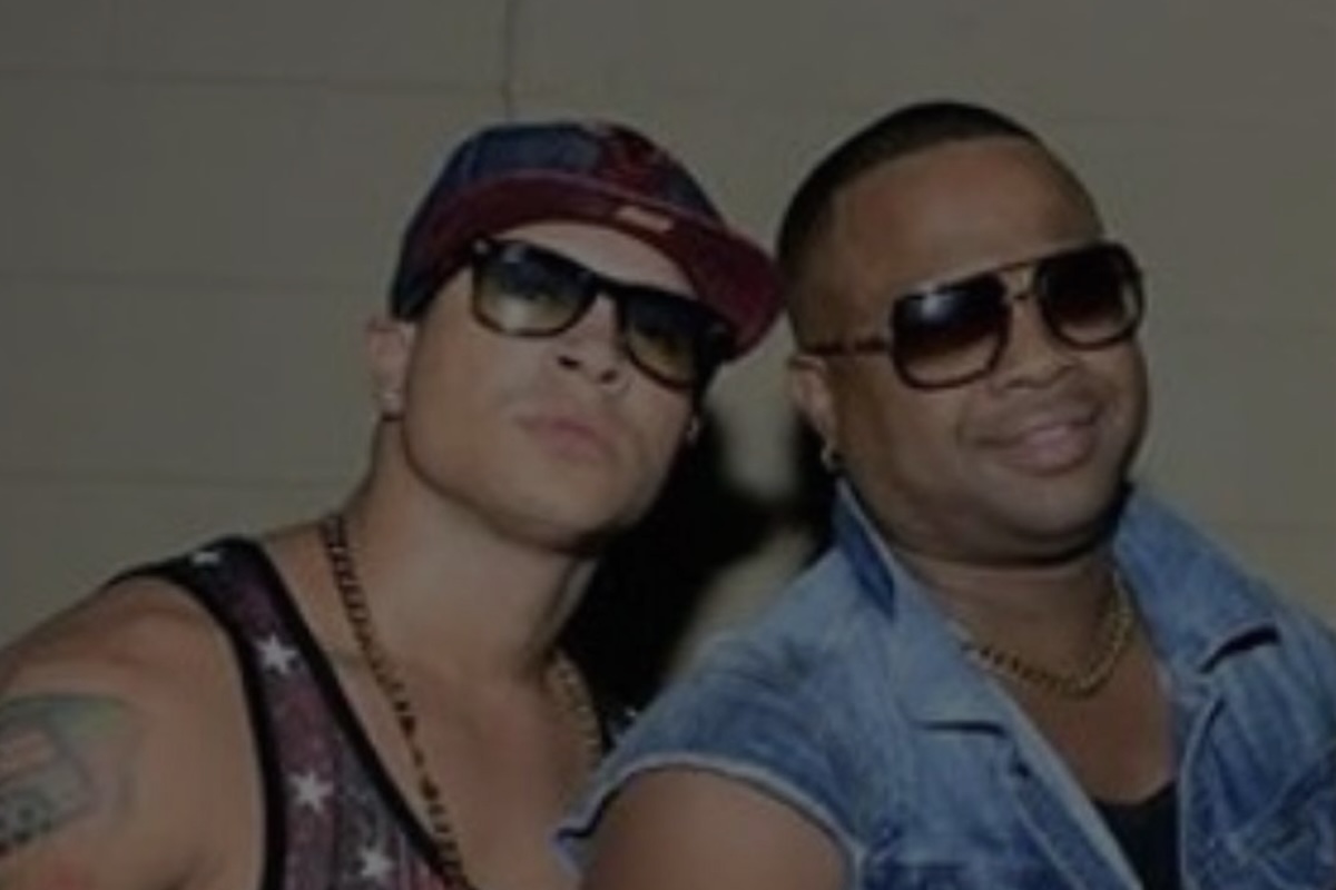 Dos hombres con gafas y gorra posando juntos