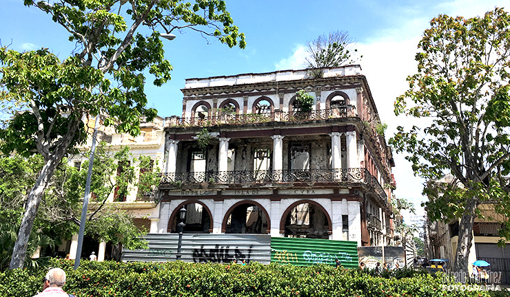 Edificio histórico deteriorado con árboles en primer plano