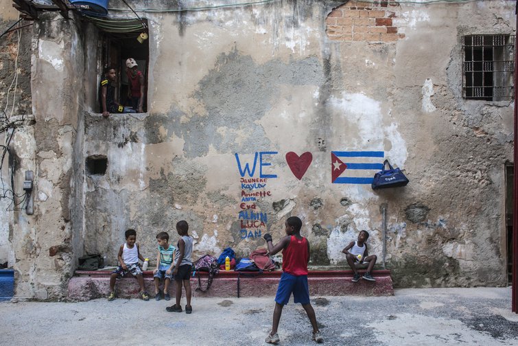 Niños jugando en patio cubano con bandera pintada