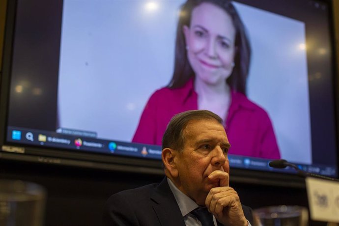 Hombre pensativo frente a pantalla con imagen de mujer sonriente