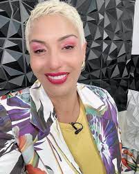 Mujer sonriente con pelo corto y camisa colorida