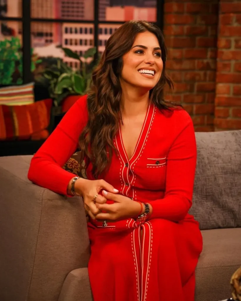 Mujer sonriente en vestido rojo sentada en sofá