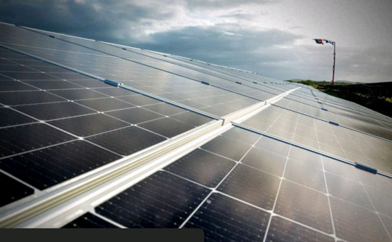 Paneles solares en campo bajo cielo nublado