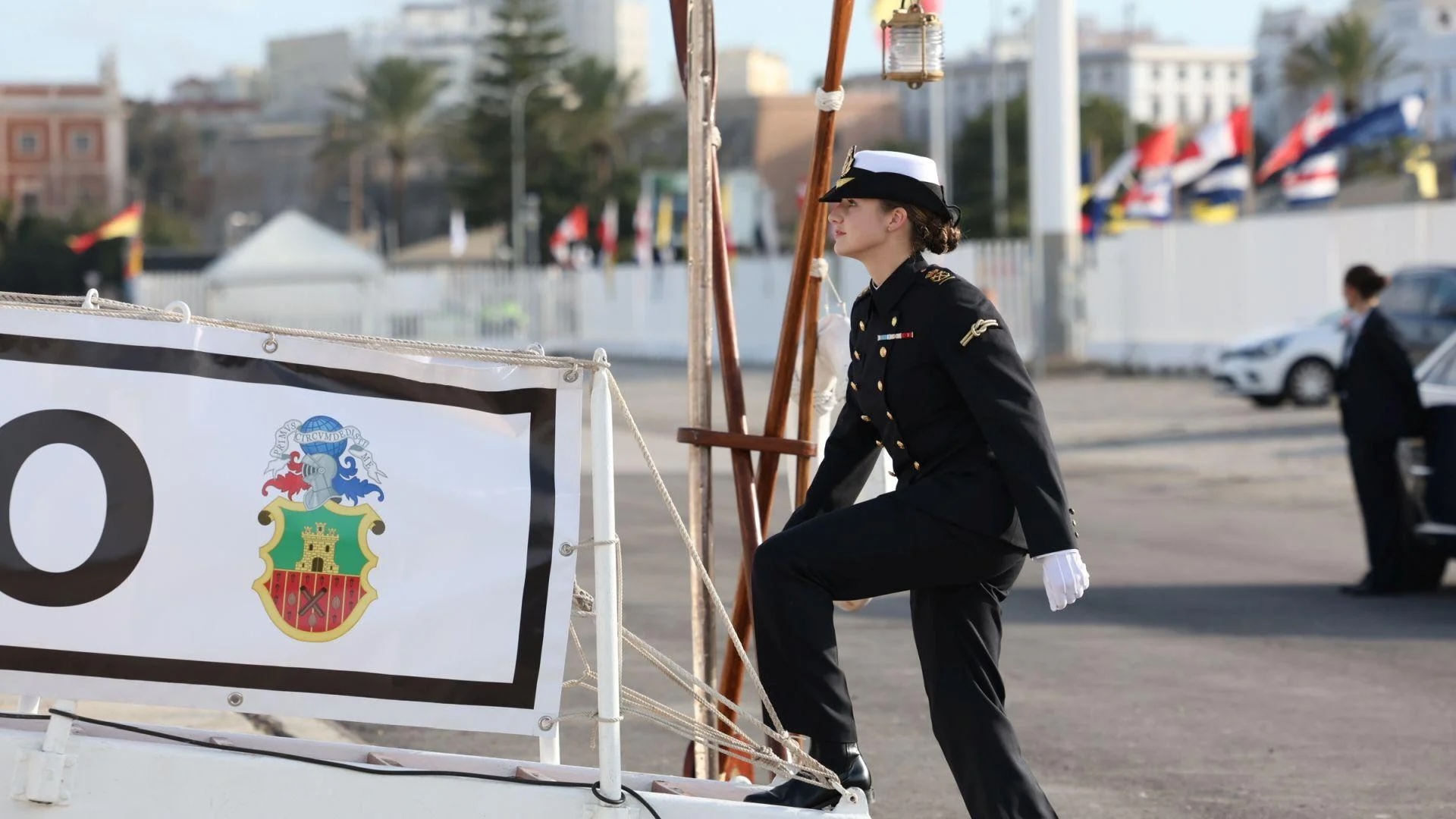 Oficial naval femenina junto a cartel simbólico