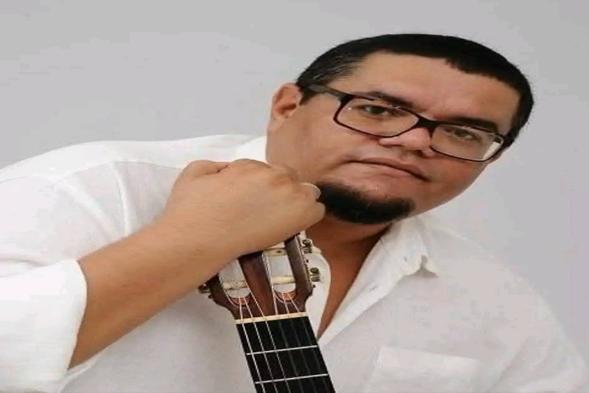 Hombre con gafas sostiene guitarra