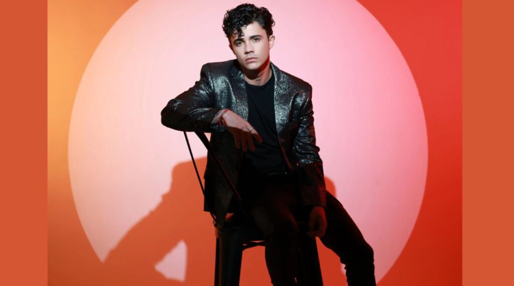 Hombre joven con chaqueta brillante posando