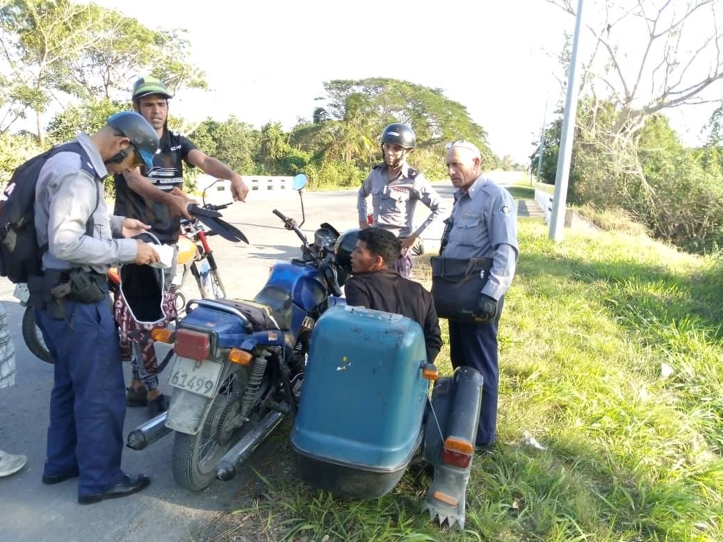 Agentes revisan documentación de motociclistas al lado del camino