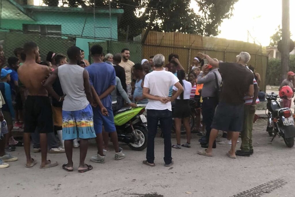 Grupo de personas reunidas en calle al atardecer