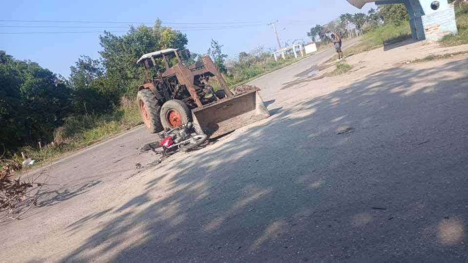 Tractor viejo junto a bicicleta caída en carretera