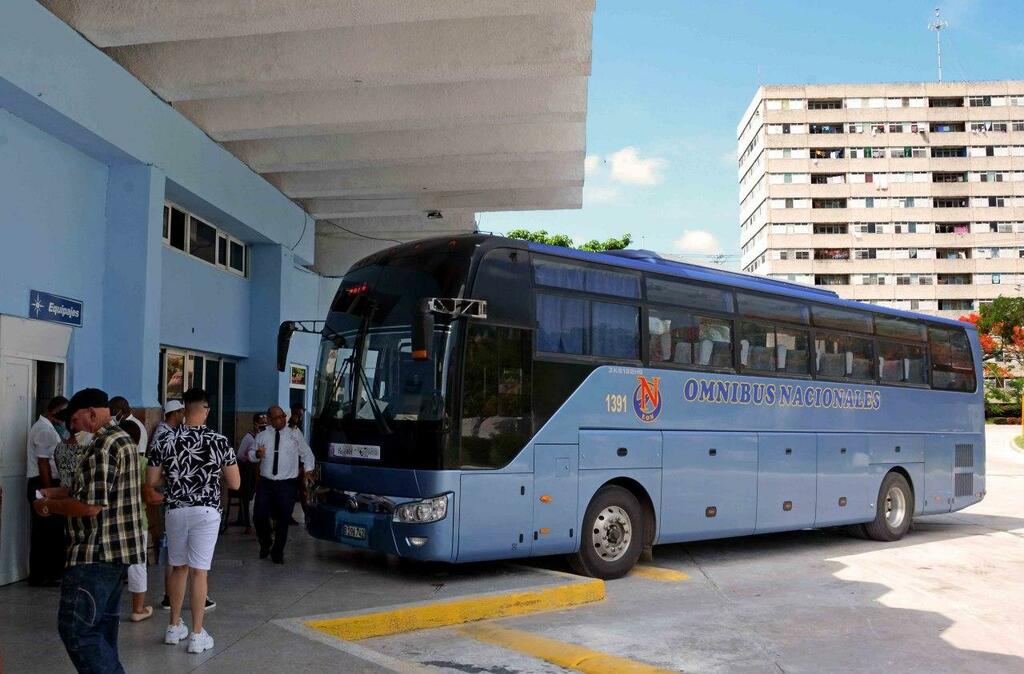 Autobús y pasajeros en estación terminal
