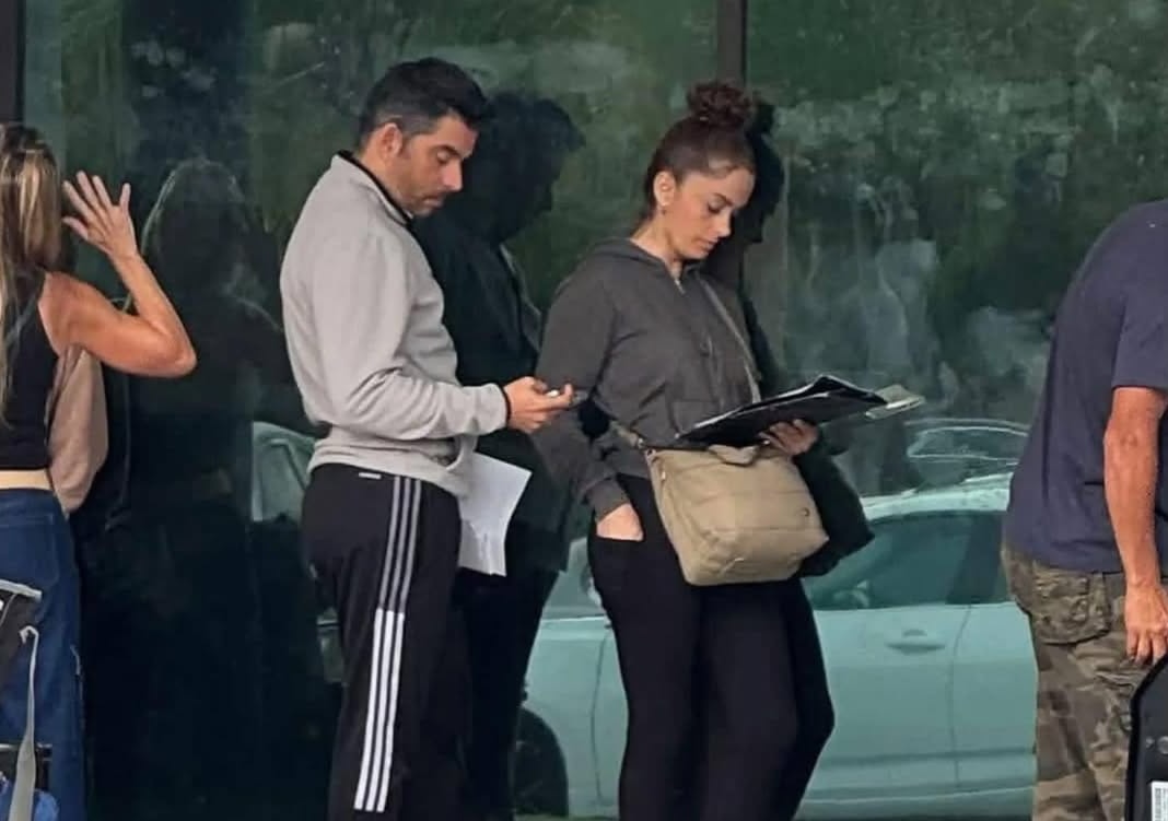 Grupo de personas revisando documentos bajo la lluvia