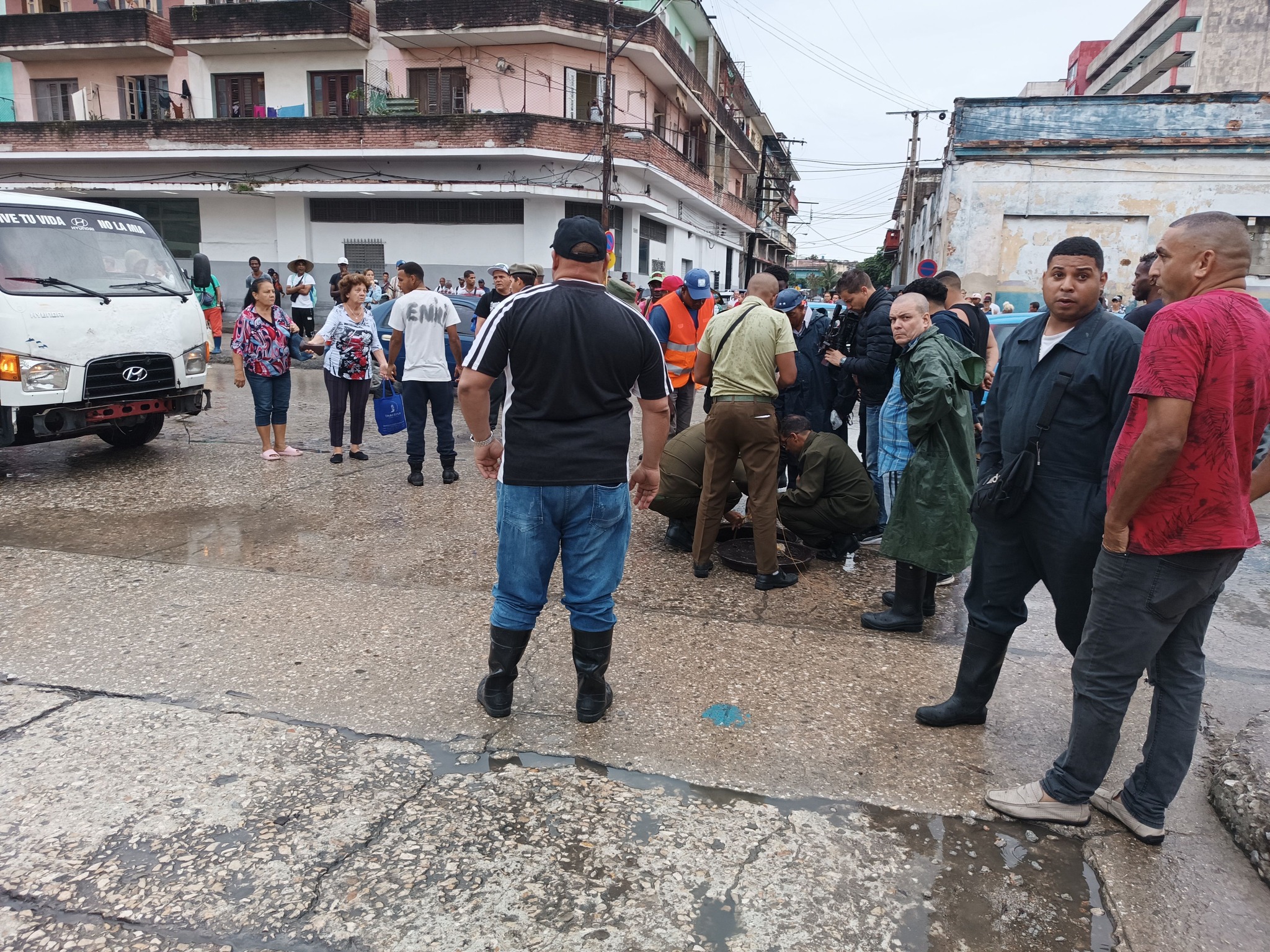 Personas congregadas en calle mojada de ciudad