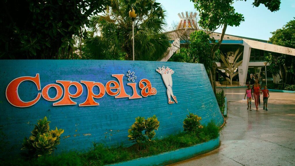Letrero de Coppelia con personas caminando al fondo