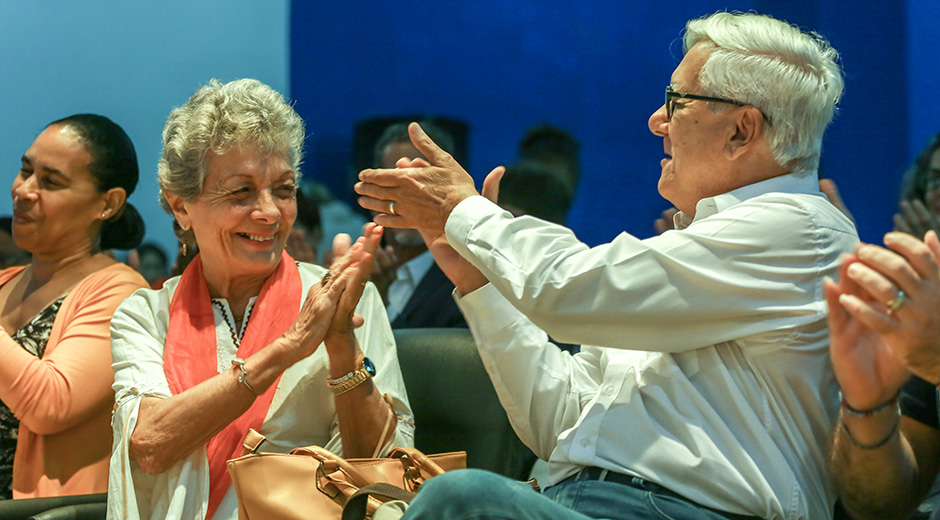 Dos adultos mayores felices aplaudiendo en evento
