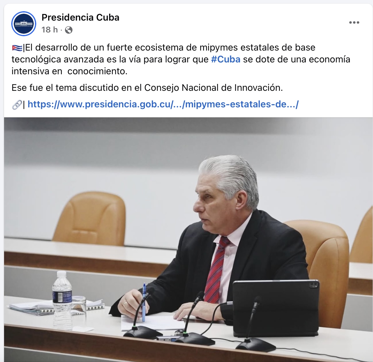Hombre en conferencia con micrófonos y bloc de notas