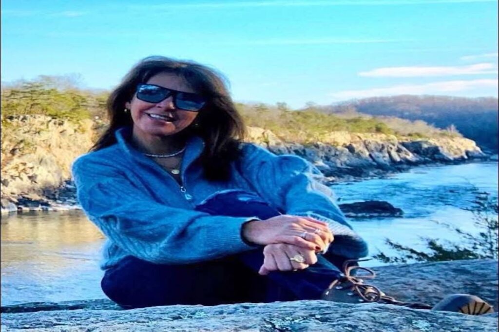 Mujer sonriente con gafas en paisaje rocoso y río